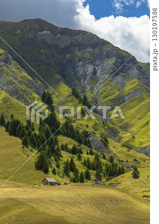 Small wooden house standing on a mountain slope in the French Alps Small wooden house standing on a mountain slope in the French Alps 130197586