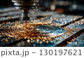 CNC milling machine carving metal with golden shavings 130197621