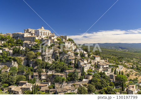 Gordes dominating the landscape in Provence, France, under a blue sky 130197799