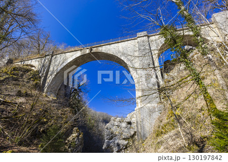 Devil's Bridge arching over the Loue River in Crouzet Migette, Doubs, France Devil's Bridge arching over the Loue River in Crouzet Migette, Doubs, France 130197842