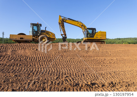 Excavator and soil compactor working on a construction site in Lubenec, Czechia Excavator and soil compactor working on a construction site in Lubenec, Czechia 130197954