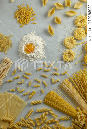 Various types of italian pasta forming a circle around flour and egg yolk Various types of italian pasta forming a circle around flour and egg yolk 130198033