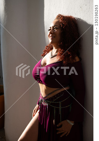 Confident Woman in Stylish Outfit Enjoying Sunlight Against White Wall Confident Woman in Stylish Outfit Enjoying Sunlight Against White Wall 130198263