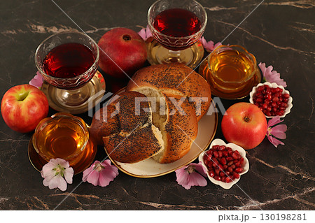 Creative autumn composition for the Jewish holiday Ro Hashanah. Layout with symbols of the Jewish New Year, template with honey, apples, pomegranate, red wine, challah bread and flowers 130198281