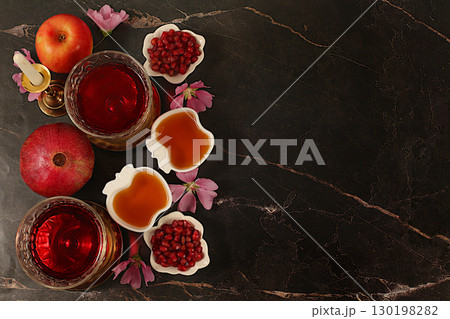 Layout with symbols of the Jewish New Year, template with honey, apples, pomegranate, red wine and flowers. Creative composition for congratulations on the Jewish holiday Ro hashanah, autumn banner Layout with symbols of the Jewish New Year, template with honey, apples, pomegranate, red wine and flowers. Creative composition for congratulations on the Jewish holiday Ro hashanah, autumn banner 130198282