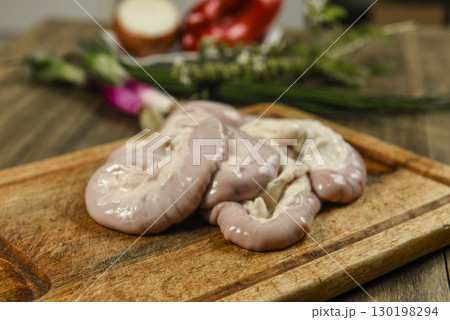 Cow bowels presented on a wooden board with ingredients, ready to grill 130198294