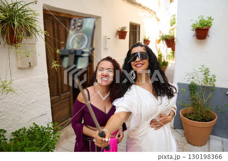 Two Women Smiling and Posing for a Selfie in a Picturesque Alley Two Women Smiling and Posing for a Selfie in a Picturesque Alley 130198366