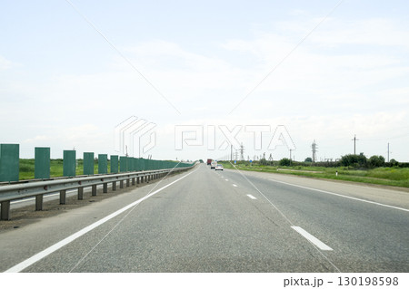 A one-way track, cars are driving along the road. 130198598
