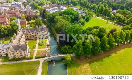 Aerial view of Cambridge University with punting boats sailing on the river Cam in a sunny summer 130198756