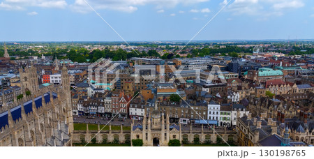 Cambridge cityscape featuring rooftops, Cambridge University and green spaces under a cloudy sky Cambridge cityscape featuring rooftops, Cambridge University and green spaces under a cloudy sky 130198765