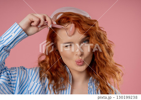 Charming Woman Doing Face Massage With Rose Quartz Stone Roller For Firmer 130199238