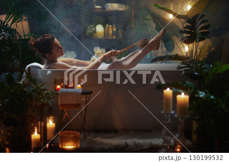 Home Spa Day: Woman Exfoliating in Candlelight Home Spa Day: Woman Exfoliating in Candlelight 130199532