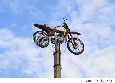 Motorcycle on the pedestal. A light motorbike on a pole, put up 130199614