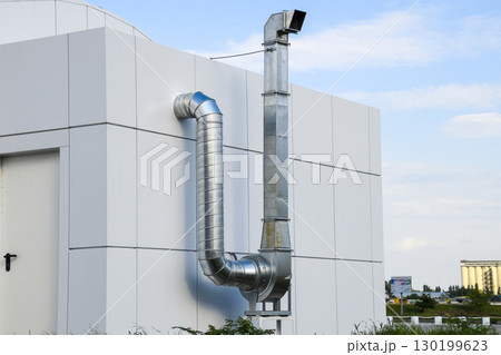 Ventilation hood with a pipe behind the cafe building. Ventilation hood with a pipe behind the cafe building. 130199623