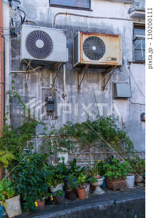 壁にエアコンの室外機が取り付けられた熱海の古い建築物	 130200111