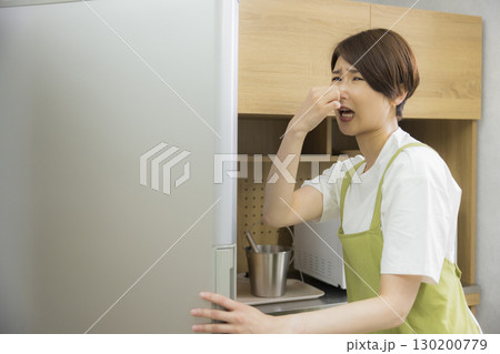 冷蔵庫を開けるエプロン姿の女性 130200779
