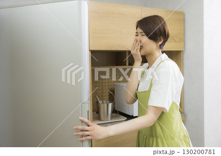 冷蔵庫を開けるエプロン姿の女性 冷蔵庫を開けるエプロン姿の女性 130200781