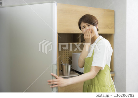 冷蔵庫を開けるエプロン姿の女性 冷蔵庫を開けるエプロン姿の女性 130200782