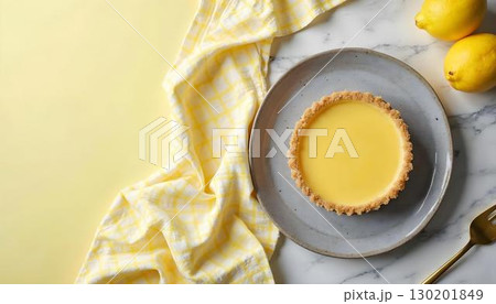 A slice of lemon cheesecake served on a plate with fresh lemons, showcasing a delightful spring dessert 130201849