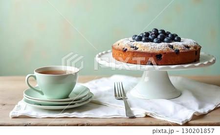A slice of blueberry coffee cake served with tea on a rustic wooden table, perfect for a spring dessert A slice of blueberry coffee cake served with tea on a rustic wooden table, perfect for a spring dessert 130201857