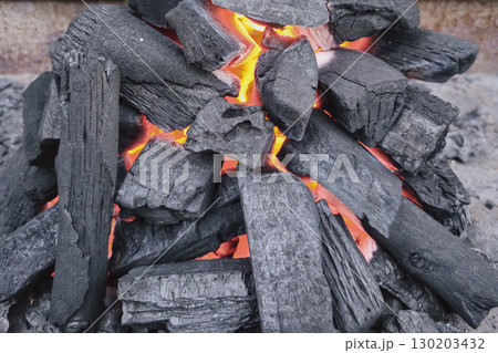 Charcoal fire background for picnic with black coals and vibrant flames Charcoal fire background for picnic with black coals and vibrant flames 130203432