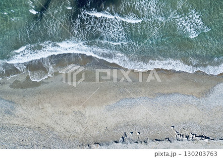Overhead drone perspective of shoreline and sparkling foamy waves, ideal background Overhead drone perspective of shoreline and sparkling foamy waves, ideal background 130203763