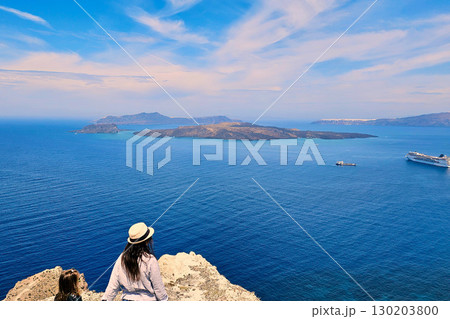 Family looks at cruise liner and Aegean Sea from Santorini viewpoint Family looks at cruise liner and Aegean Sea from Santorini viewpoint 130203800