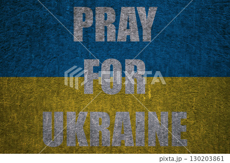 Patriotic background, Ukrainian flag on textured plaster wall with text PRAY FOR UKRAINE 130203861