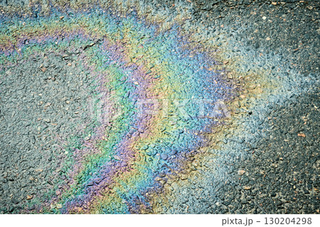 Iridescent gasoline spill creating a rainbow effect on a wet asphalt road Iridescent gasoline spill creating a rainbow effect on a wet asphalt road 130204298