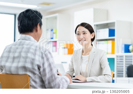 シニアの男性に営業するミドルのビジネスウーマン 130205005