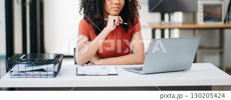 Confident woman with a smile standing holding notepad and tablet at the modern office. 130205424
