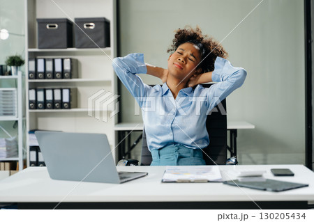Overworked young businesswoman office worker suffering from neck pain after had a long day. office syndrome concept 130205434
