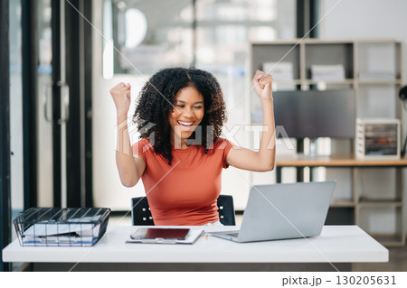 Business woman are delighted and happy with the work they do on their tablet, laptop and taking notes 130205631