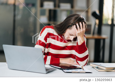 Woman feeling migraine head strain.Overworked businesswoman financier while working on laptop and tablet Woman feeling migraine head strain.Overworked businesswoman financier while working on laptop and tablet 130205663