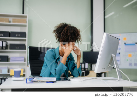 Asian business woman is stressed, bored, and overthinking from working on a tablet at the modern office. Asian business woman is stressed, bored, and overthinking from working on a tablet at the modern office. 130205776