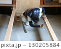 大工さんが土間コンクリートと大引の間の鋼製束を調整している 130205884