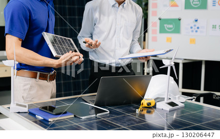 Alternative energy engineers discussing a project with a worker businesspeople a meeting in solar cell panel Alternative energy engineers discussing a project with a worker businesspeople a meeting in solar cell panel 130206447
