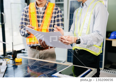 Alternative energy engineers discussing a project with a worker businesspeople a meeting in solar cell panel Alternative energy engineers discussing a project with a worker businesspeople a meeting in solar cell panel 130206656