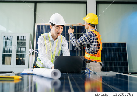 Two Asian engineers collaborate on solar and wind energy, driving clean innovation and sustainability. Two Asian engineers collaborate on solar and wind energy, driving clean innovation and sustainability. 130206768