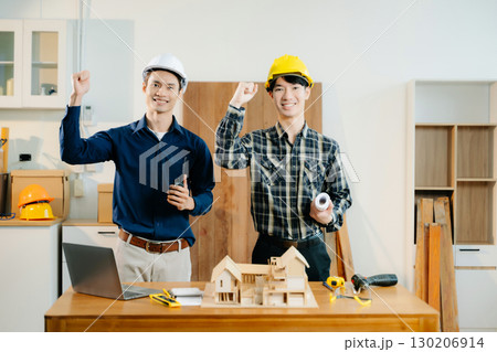 Architects and engineers collaborate on a building model, designing, planning, and measuring with teamwork, 130206914