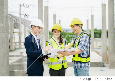 Contractor and architect looking at plan, tablet, laptop and talking about working on big project. 130207162
