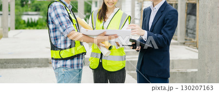 Contractor and architect looking at plan, tablet, laptop and talking about working on big project. Contractor and architect looking at plan, tablet, laptop and talking about working on big project. 130207163