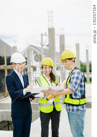 Contractor and architect looking at plan, tablet, laptop and talking about working on big project. Contractor and architect looking at plan, tablet, laptop and talking about working on big project. 130207164