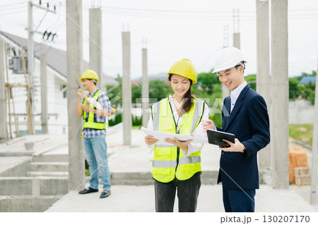 Contractor and architect looking at plan, tablet, laptop and talking about working on big project. Contractor and architect looking at plan, tablet, laptop and talking about working on big project. 130207170