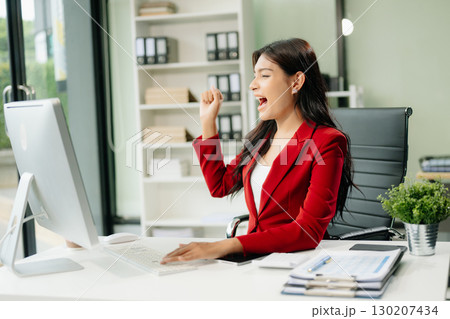 Asian woman using laptop and tablet while sitting at her working place 130207434