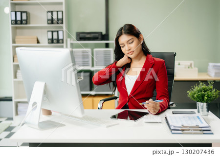 Overworked young Asian businesswoman office worker suffering from neck pain after had a long day 130207436