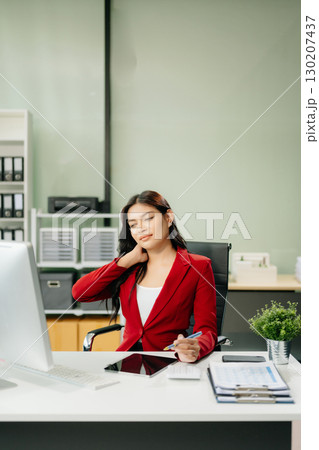 Overworked young Asian businesswoman office worker suffering from neck pain after had a long day 130207437