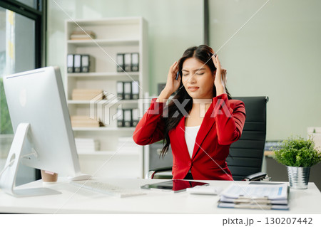 Overworked young Asian businesswoman office worker suffering from neck pain after had a long day 130207442