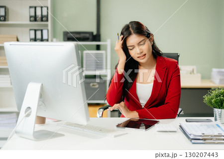 Overworked young Asian businesswoman office worker suffering from neck pain after had a long day 130207443