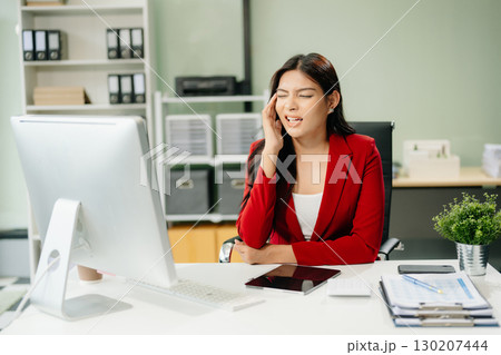 Overworked young Asian businesswoman office worker suffering from neck pain after had a long day 130207444